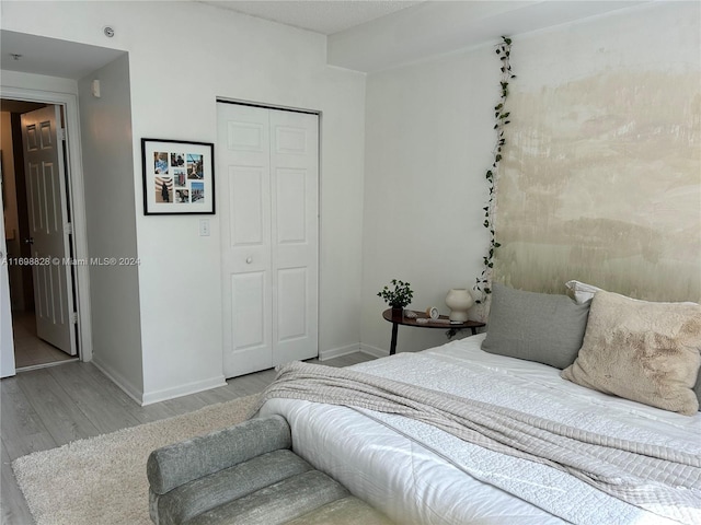 bedroom with a closet and light hardwood / wood-style flooring