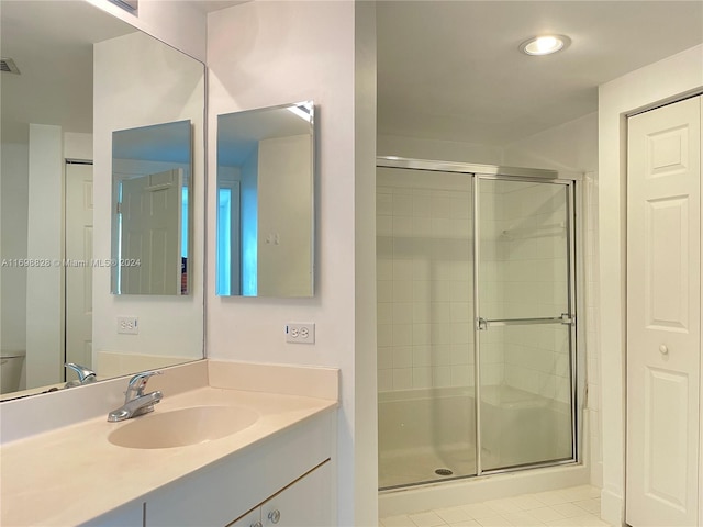 bathroom featuring tile patterned floors, vanity, toilet, and an enclosed shower