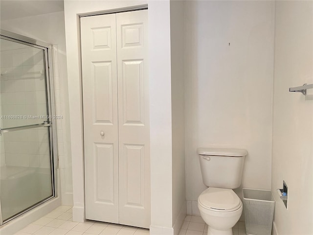 bathroom featuring toilet, tile patterned floors, and an enclosed shower