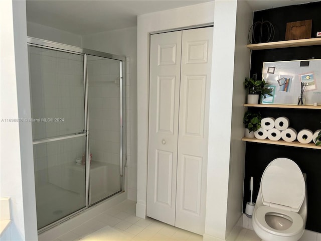 bathroom with tile patterned flooring, toilet, and an enclosed shower