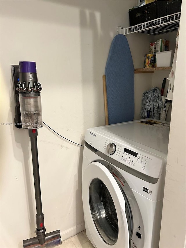 laundry area with light tile patterned flooring and washer / dryer