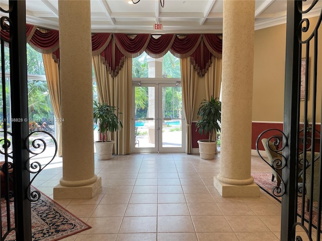 entrance foyer with french doors, decorative columns, ornamental molding, coffered ceiling, and light tile patterned floors