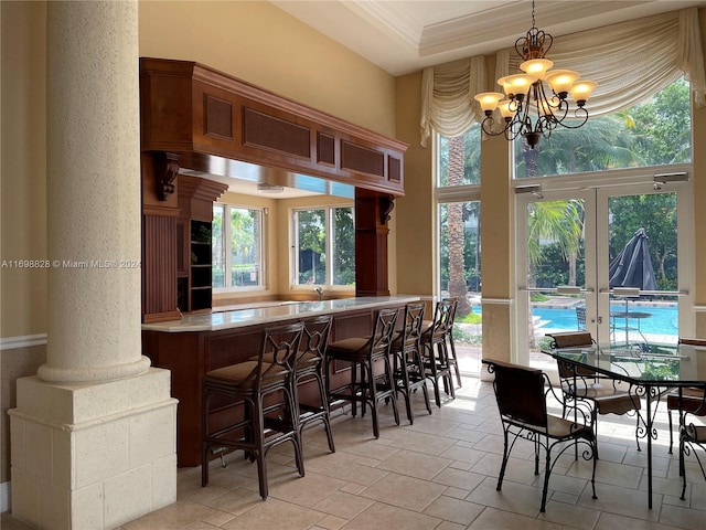 interior space featuring french doors, decorative columns, and plenty of natural light