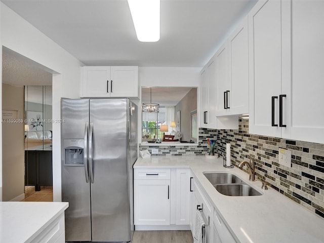 kitchen featuring white cabinets, stainless steel refrigerator with ice dispenser, and sink