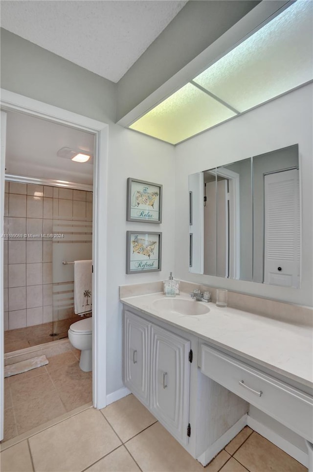 bathroom featuring tile patterned floors, walk in shower, vanity, and toilet