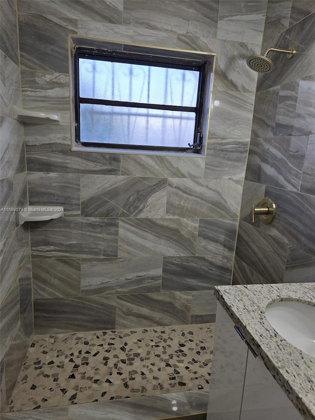 bathroom with walk in shower, vanity, and plenty of natural light