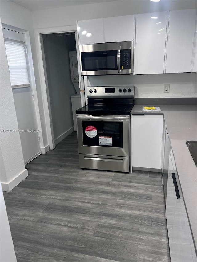 kitchen featuring white cabinets, appliances with stainless steel finishes, and dark wood-type flooring