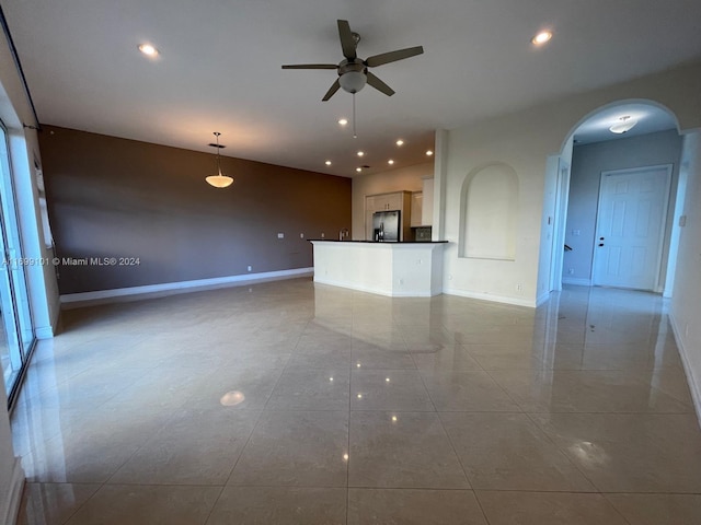 unfurnished living room with ceiling fan and light tile patterned floors