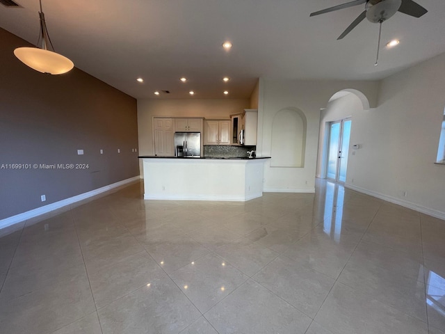 unfurnished living room featuring ceiling fan and light tile patterned floors