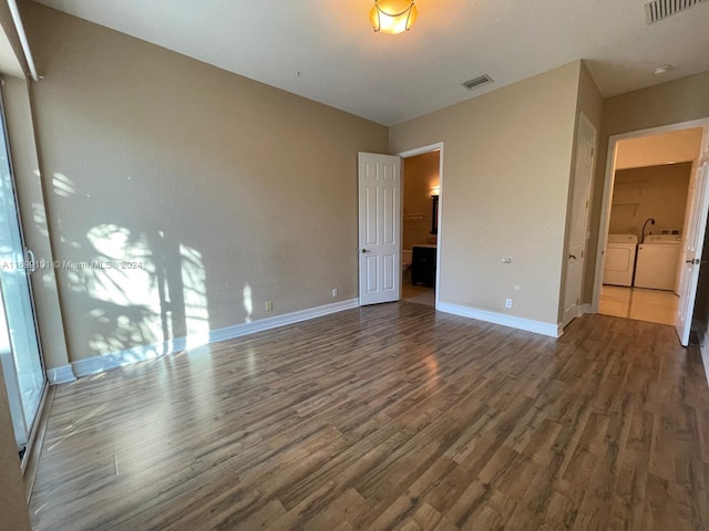 unfurnished bedroom featuring washer and dryer and dark wood-type flooring