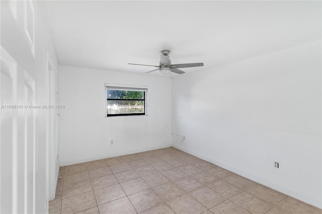 tiled spare room featuring ceiling fan