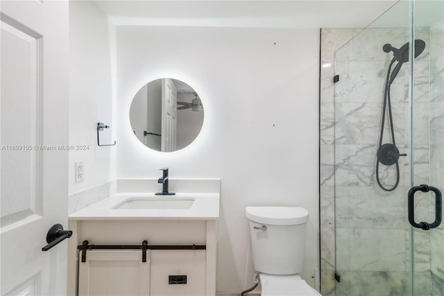 bathroom featuring vanity, toilet, and a shower with door