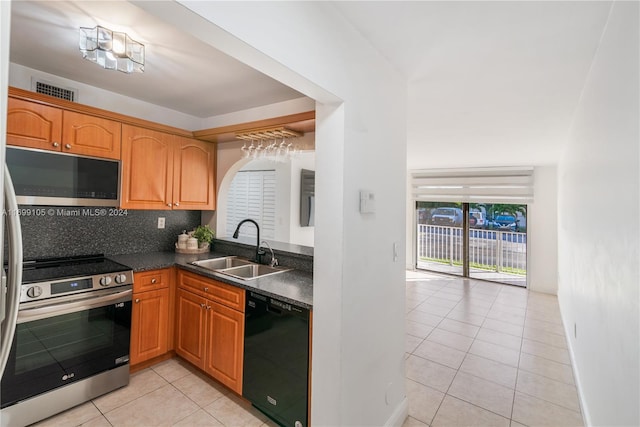 kitchen with backsplash, light tile patterned flooring, sink, and appliances with stainless steel finishes