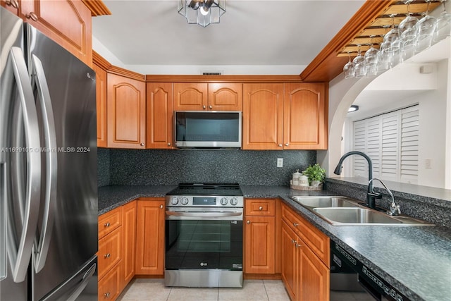 kitchen with decorative backsplash, sink, light tile patterned floors, and appliances with stainless steel finishes