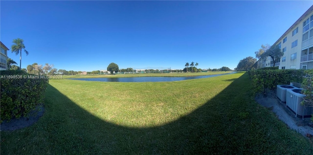 view of yard featuring a water view and central air condition unit