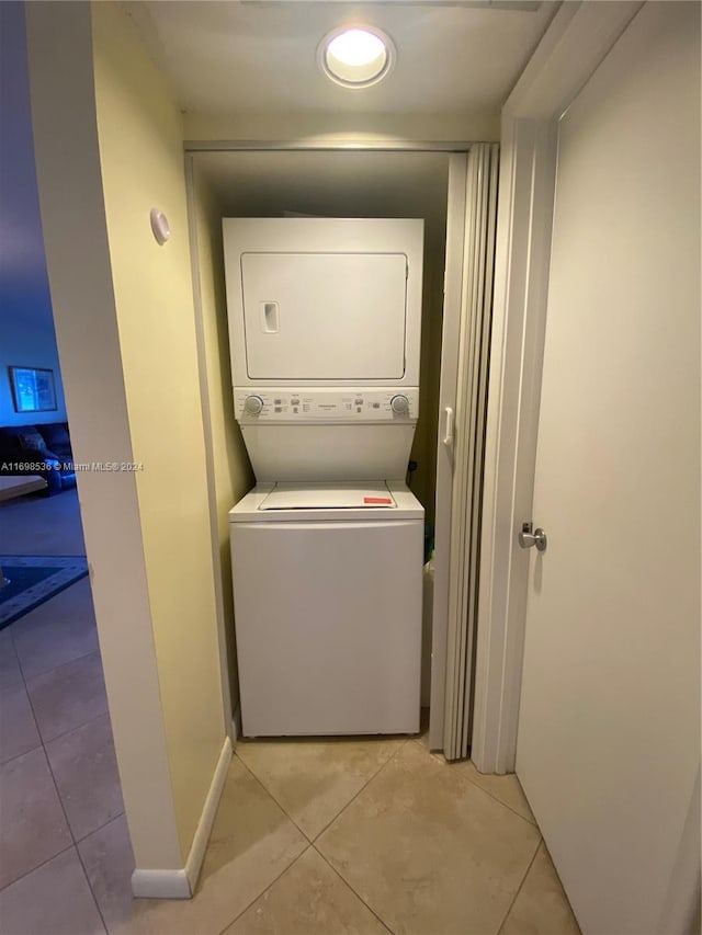 washroom featuring light tile patterned floors and stacked washer / drying machine