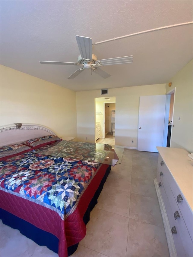 tiled bedroom with connected bathroom and ceiling fan