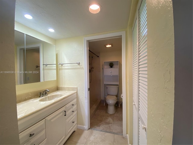 bathroom featuring tile patterned floors, vanity, toilet, and walk in shower