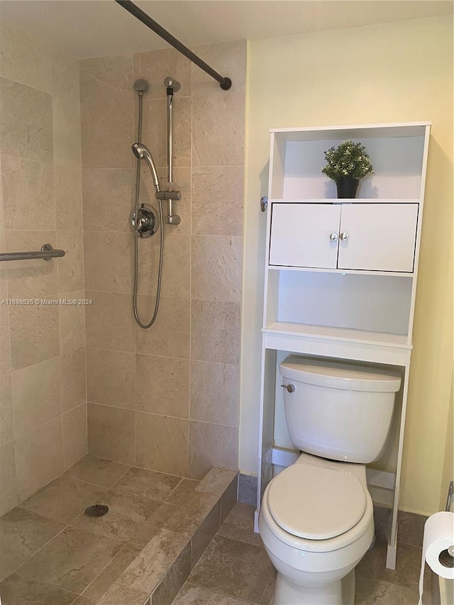 bathroom with a tile shower and toilet