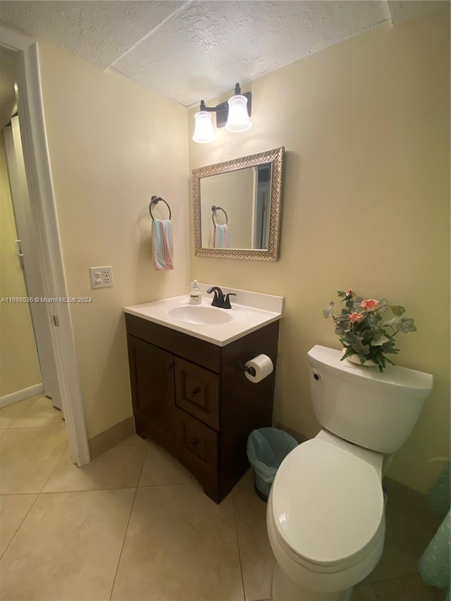 bathroom featuring tile patterned floors, vanity, a textured ceiling, and toilet