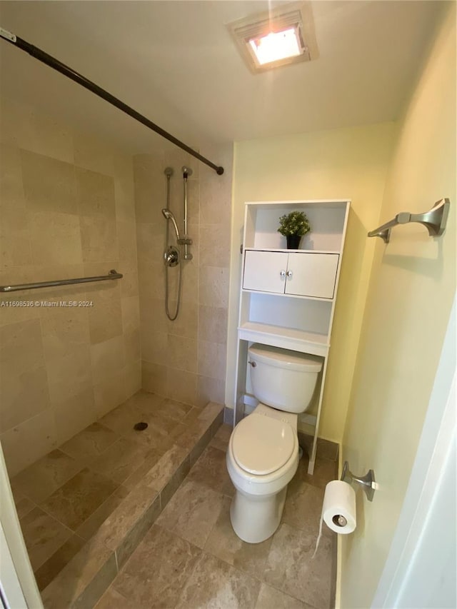 bathroom with tiled shower and toilet