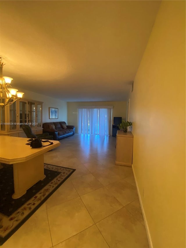 hallway featuring tile patterned flooring and a notable chandelier