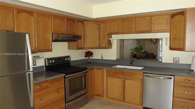 901 SW 128th Ter Unit 103A, Pembroke Pines, FL 33027 - kitchen with stainless steel appliances, under cabinet range hood, brown cabinetry, dark countertops, and light tile patterned floors