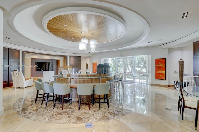 interior space featuring a raised ceiling and a breakfast bar