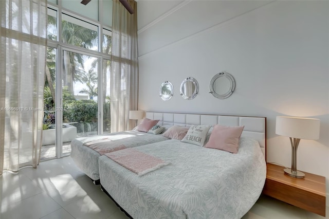 tiled bedroom featuring access to exterior, a high ceiling, and ornamental molding