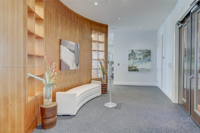 corridor with wood walls and carpet floors