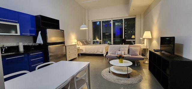 bedroom with sink, stainless steel refrigerator, and concrete floors