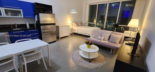 bedroom featuring concrete flooring, stainless steel refrigerator, and sink