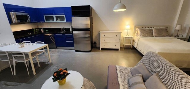 kitchen with blue cabinetry, stainless steel appliances, and hanging light fixtures