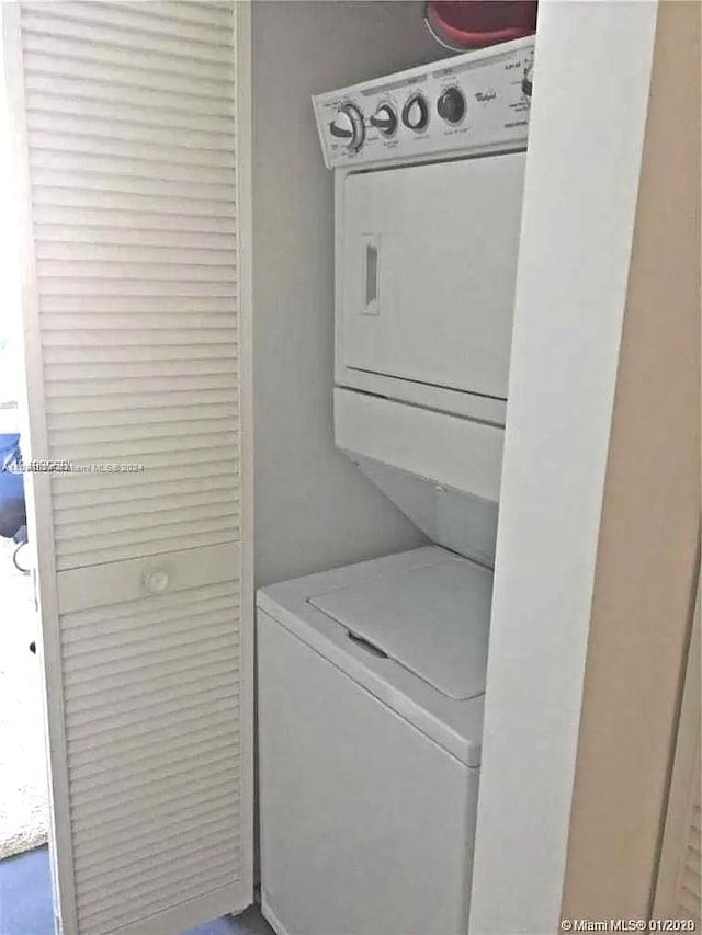 clothes washing area with stacked washer and clothes dryer