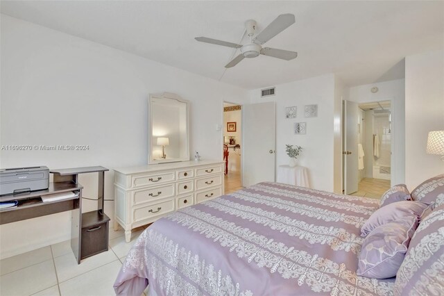 bedroom featuring ceiling fan, light tile patterned flooring, and ensuite bathroom