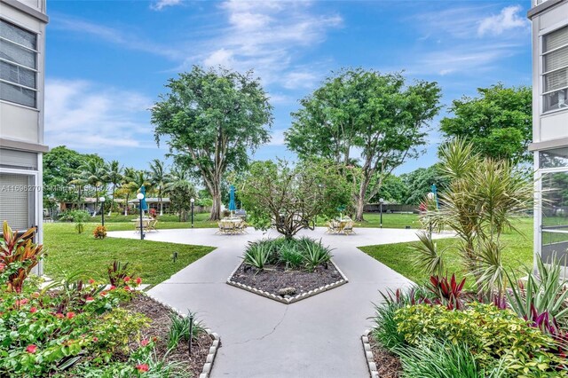 view of property's community with a yard and a patio