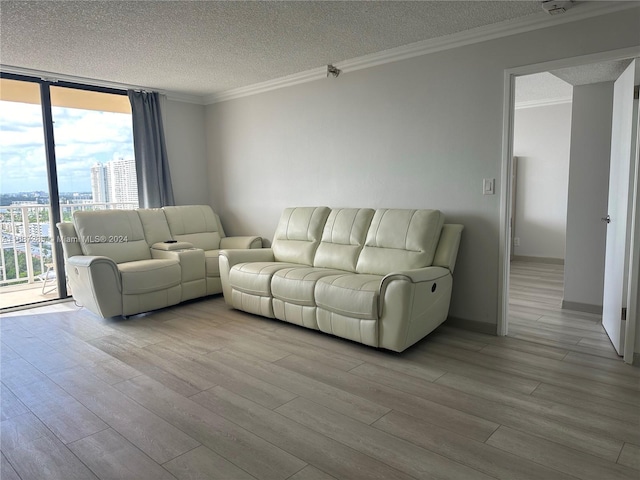 living room featuring crown molding, light hardwood / wood-style flooring, a textured ceiling, and a wall of windows