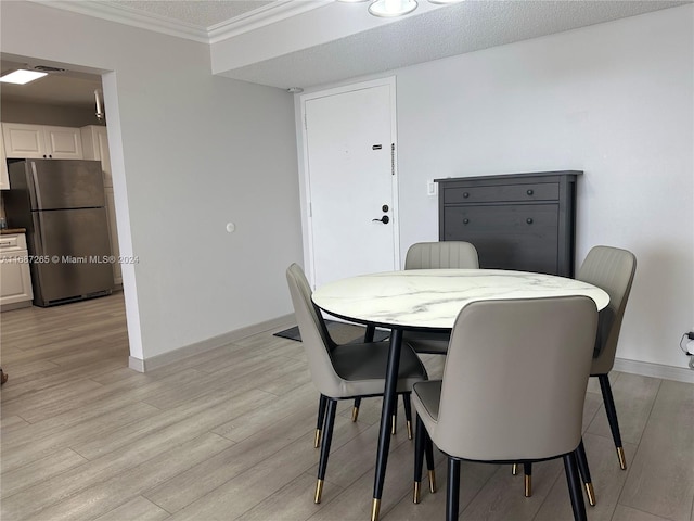 dining space with crown molding, light wood-type flooring, and a textured ceiling