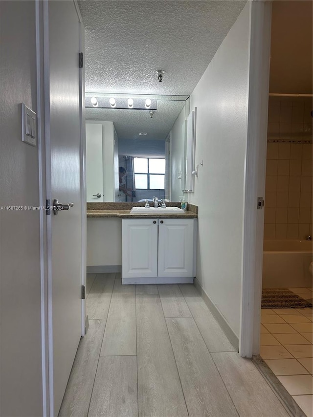 bathroom featuring hardwood / wood-style floors, vanity, and a textured ceiling