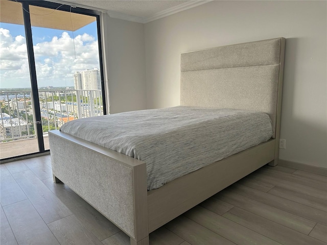 bedroom with hardwood / wood-style flooring, access to outside, and multiple windows