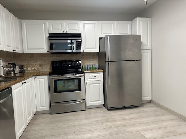 kitchen with white cabinets, sink, appliances with stainless steel finishes, and light hardwood / wood-style flooring