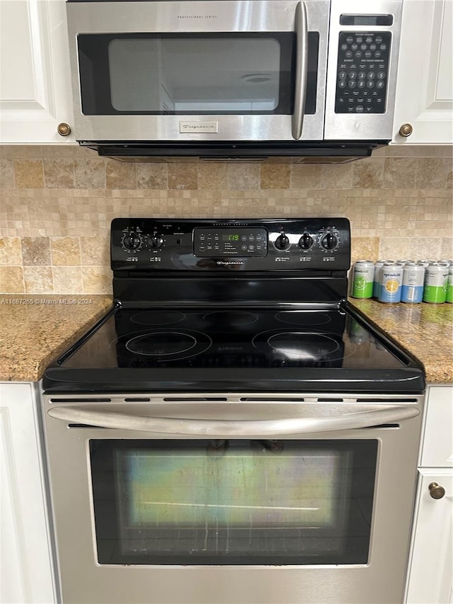 kitchen with backsplash, stainless steel appliances, white cabinetry, and light stone counters