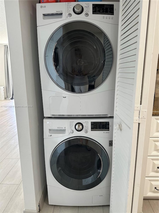 laundry area featuring light tile patterned flooring and stacked washing maching and dryer