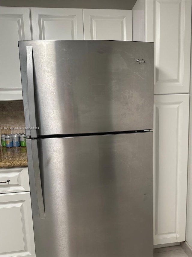 room details featuring white cabinetry and stainless steel refrigerator