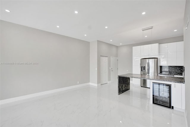 kitchen featuring hanging light fixtures, wine cooler, stainless steel fridge with ice dispenser, light stone countertops, and white cabinetry