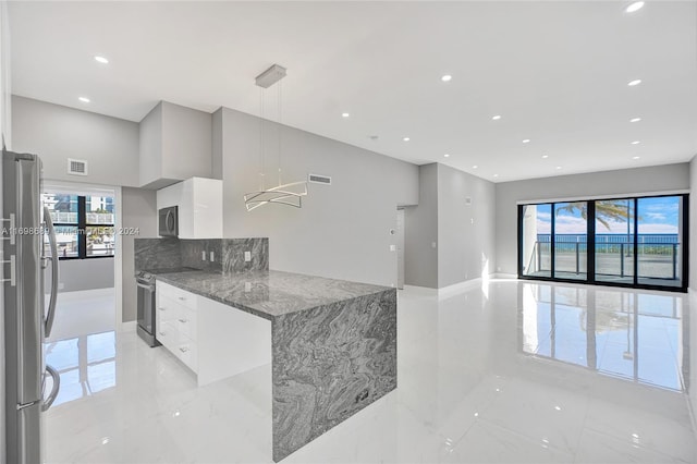 kitchen featuring white cabinets, decorative light fixtures, a healthy amount of sunlight, and appliances with stainless steel finishes