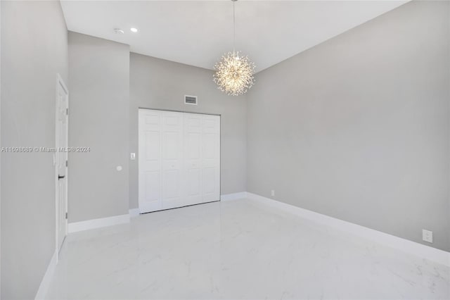 unfurnished bedroom featuring a closet and a notable chandelier