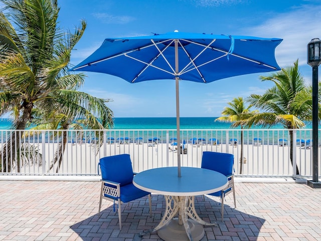 view of patio with a water view and a view of the beach