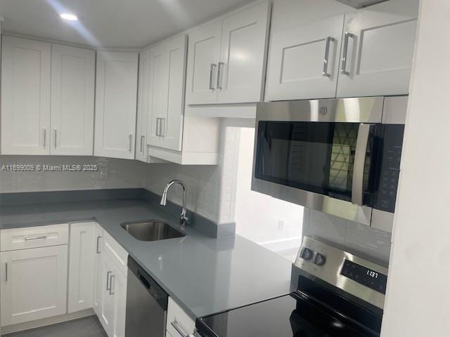 kitchen with appliances with stainless steel finishes, sink, and white cabinets