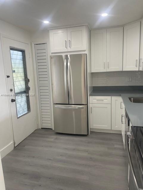 kitchen with dark hardwood / wood-style flooring, sink, stainless steel appliances, and white cabinets